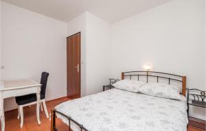 a bedroom with a bed and a table and a desk at Amazing Apartment In Barbat Na Rabu in Barbat na Rabu