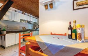 a kitchen with a table with bottles of wine at Amazing Apartment In Novi Vinodolski With Wifi in Novi Vinodolski