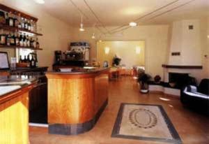 a kitchen with a bar and a living room at Hotel Il Saraceno in Volastra