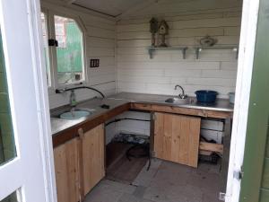 a small kitchen with two sinks and a window at Wijndomein de Vier Ambachten -overnachten in de wijngaard in Simonshaven