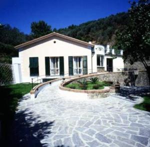 a house with a stone walkway in front of it at Hotel Il Saraceno in Volastra