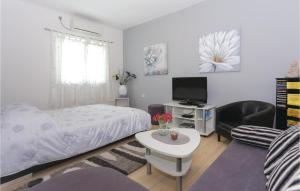 Schlafzimmer mit einem Bett, einem TV und einem Tisch in der Unterkunft 1 Bedroom Gorgeous Apartment In Podstrana in Podstrana