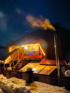 eine Achterbahn, die nachts im Schnee leuchtete in der Unterkunft ЛІСОВА ХАТИНКА in Kelechin