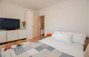um quarto com uma cama branca e uma televisão de ecrã plano em 1 Bedroom Awesome Apartment In Sibenik em Sibenik