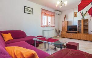 a living room with a purple couch and a glass table at Awesome Apartment In Zminj With 2 Bedrooms And Wifi in Žminj
