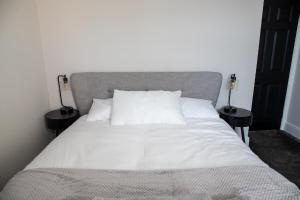 Una cama con sábanas blancas y almohadas en un dormitorio en Withnell Stays - Apartment Two, en Blackpool