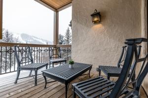 a porch with two chairs and a table on a deck at Beaver Creeks Meadows Ski-In Ski-Out in Beaver Creek