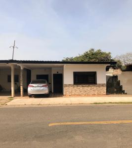 une voiture garée devant une maison dans l'établissement Hostal Familiar Los Girasoles, à Chitré