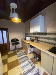 eine Küche mit einem Schreibtisch und einem Stuhl darin in der Unterkunft ЛІСОВА ХАТИНКА in Kelechin