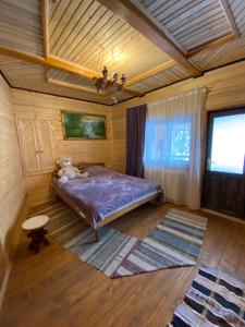 KelechinにあるЛІСОВА ХАТИНКАの木製の部屋に紫色のベッドが備わるベッドルーム1室が備わります。