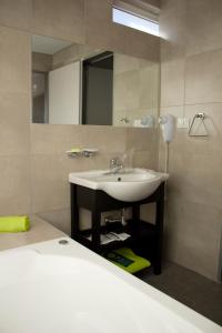 een badkamer met een wastafel en een spiegel bij Hotel NEU 354 in Neuquén