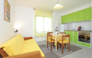 cocina con sofá amarillo y mesa con sillas en Amazing Apartment In Blato With Kitchen, en Blato
