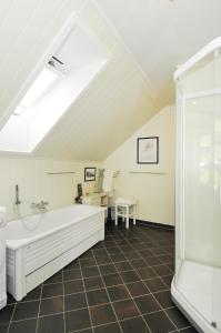 a bathroom with a white tub and a shower at Nyksund Apartments Marihaugen in Nyksund +44 photos