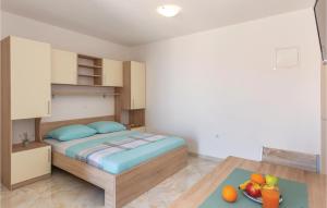 1 dormitorio pequeño con 1 cama y un bol de fruta en Beautiful Apartment In Krvavica With Kitchen, en Krvavica