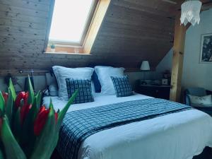 1 dormitorio con 1 cama grande y ventana en Le Nid de Cigognes en Hengwiller