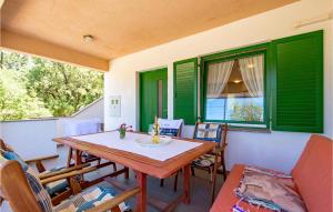 a dining room with green shutters and a table and chairs at 2 Bedroom Beautiful Apartment In Potocnica in Borovići