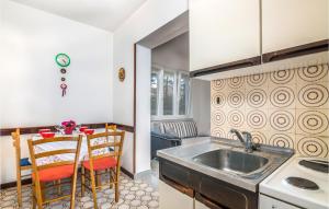 a kitchen with a sink and a table with chairs at Nice Apartment In Silo With Kitchen in Šilo