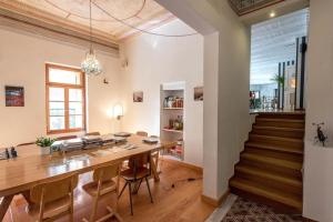 une salle à manger avec une table, des chaises et un escalier dans l'établissement City Circus Athens, à Athènes