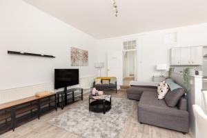 een woonkamer met een bank en een flatscreen-tv bij Portland Place in Bath in Bath