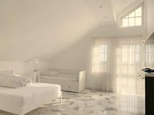 biała sypialnia z 2 łóżkami i oknem w obiekcie F10 APARTMENTS Roth w mieście Pfaffenhofen an der Roth