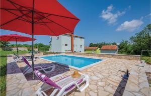 basen z 2 krzesłami i czerwonym parasolem w obiekcie Studio Apartment In Sv,lovrec w mieście Jakići