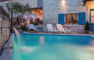 a swimming pool with two chairs at Holiday Home Orbanici Orbanici Ii in Orbanići