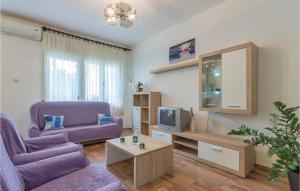 a living room with a purple couch and a tv at 2 Bedroom Amazing Apartment In Fazana in Marana