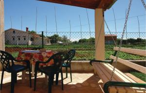 a patio with a table and chairs and a fence at 2 Bedroom Beautiful Home In Liznjan in Ližnjan
