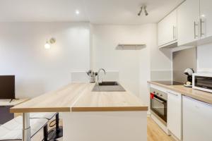 uma cozinha com armários brancos e um balcão de madeira em Très bel appartement 5 pers+1bb - 3km Disneyland em Magny-le-Hongre