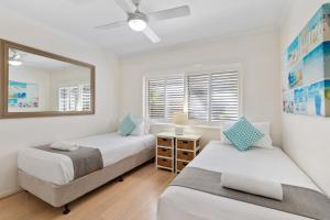 1 dormitorio con 2 camas y espejo en Culgoa Point Beach Resort, en Noosa Heads