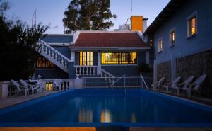a house with a swimming pool in front of a house at Hotel San Marcos in San Marcos Sierras