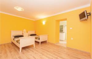 a yellow room with two bunk beds and a tv at Gorgeous Apartment In Omisalj With Kitchen in Omišalj