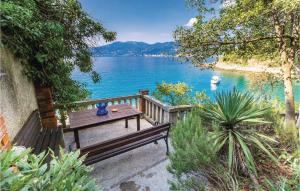 a wooden bench sitting next to a body of water at Gorgeous Apartment In Rijeka With House Sea View in Rijeka