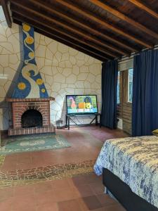 a living room with a fireplace and a tv at Refugio en el Bosque in Medellín