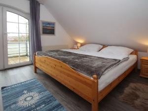 a bedroom with a bed and a large window at Semi-detached house Schwittersum, Dornum in Dornum