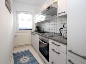 a white kitchen with a sink and a stove at Semi-detached house Schwittersum, Dornum in Dornum