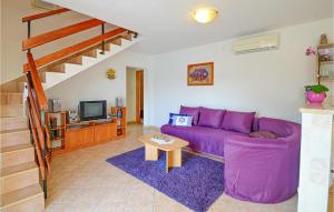 a living room with a purple couch and a tv at Beautiful Home In Rabac With House Sea View in Rabac