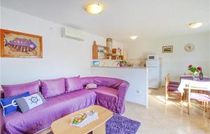 a purple couch in a living room with a table at Beautiful Home In Rabac With House Sea View in Rabac