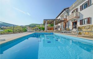 a large swimming pool next to a building at Beautiful Home In Rabac With House Sea View in Rabac