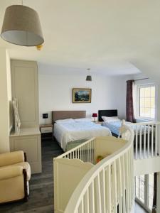 a bedroom with two beds and a crib and a staircase at Heart of Kinsale in Kinsale