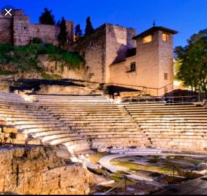 un anfiteatro con escalones y un edificio de fondo en HISTORICAL CENTER OLLERIAS en Málaga