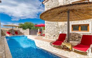 a swimming pool with chairs and an umbrella next to a house at Awesome Home In Marcana With Kitchen in Orbanići