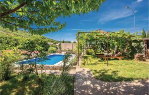 a garden with a pool and a swing at Awesome Home In Krizisce With Kitchen in Križišće