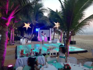 Una festa sulla spiaggia con una donna sul palco di Casa Kaukan a Zihuatanejo