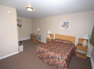 a hotel room with a bed and two night stands at Wayside Motel in Saint Ignace