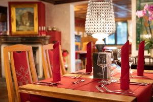 a table in a restaurant with red napkins and wine glasses at Alpin & Wellness Resort Ludwig Royal in Oberstaufen +68 photos