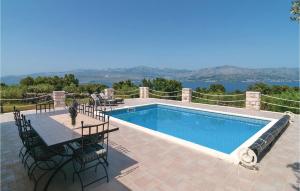 - une piscine avec une table et des chaises à côté dans l'établissement Lovely Home In Postira With House Sea View, à Postira