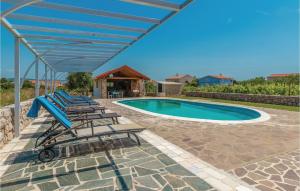 a group of lounge chairs and a swimming pool at Awesome Home In Pasman With House Sea View in Pašman