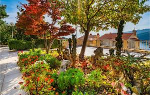 a garden with flowers and trees and a building at Gorgeous Apartment In Rabac With Wifi in Rabac