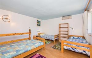 a bedroom with two beds and a book shelf at Awesome Home In Stinica With 2 Bedrooms And Wifi in Stinica
